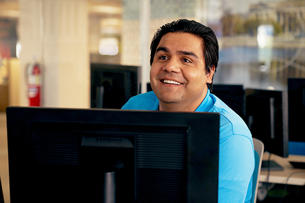 Smiling employee at desk with computer