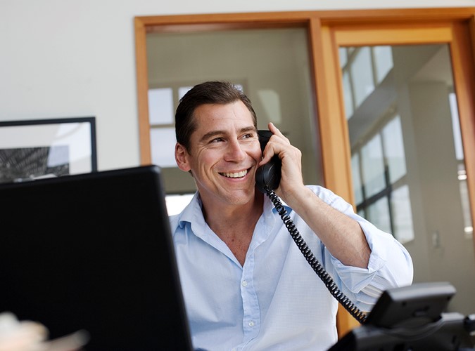 Man smiling while talking on his phone